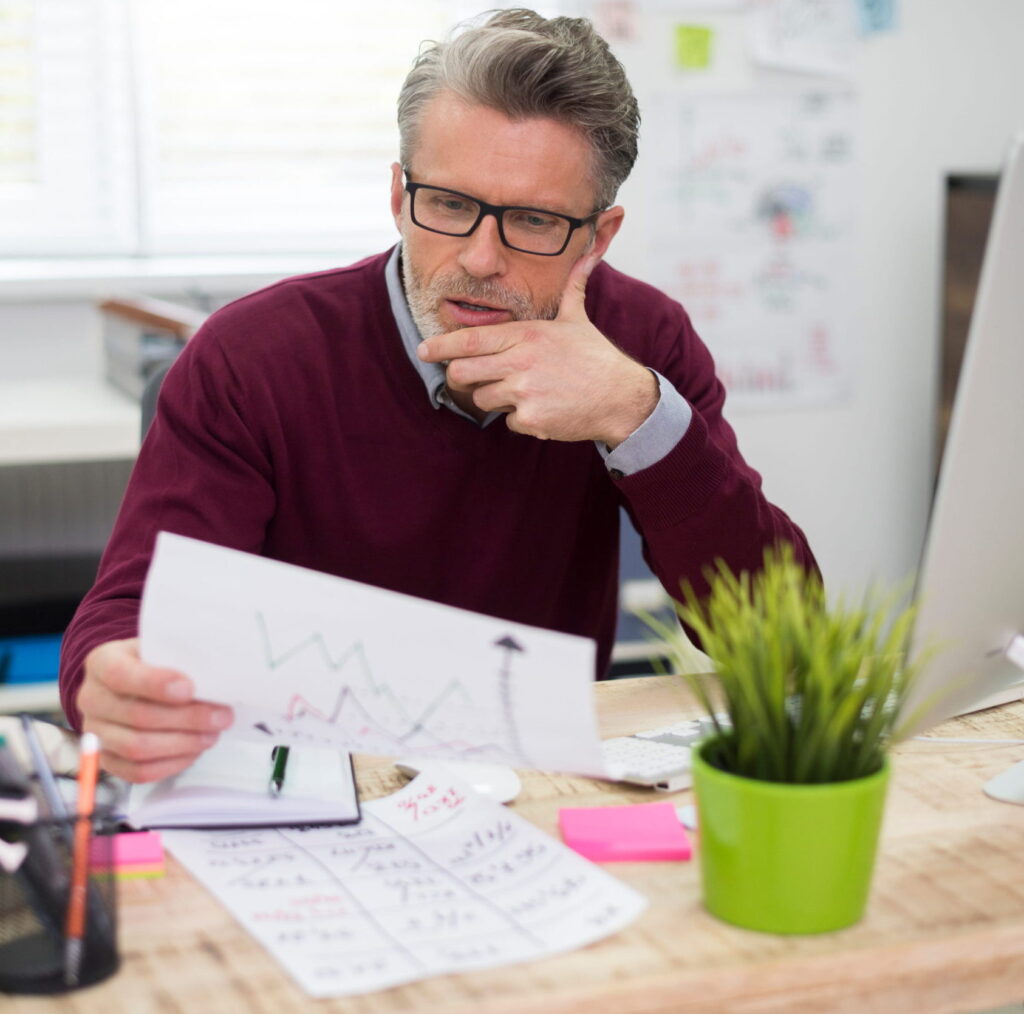 latest-data-must-be-analized (1) imagem de um pequeno empresário analisando os orçamentos da sua empresa, com uma cara preocupada.